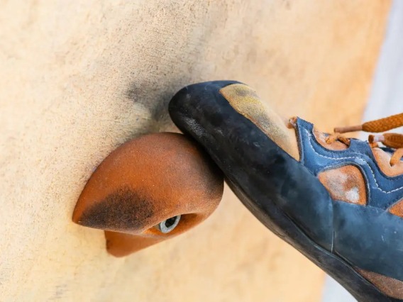 A close-up of a person’s climbing shoes