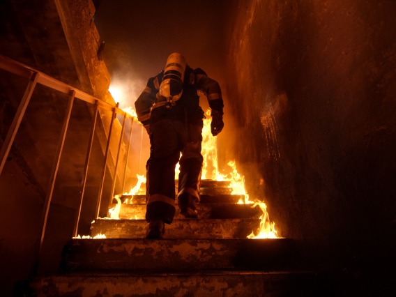 A stock image of a firefighter climbing stairs. 
