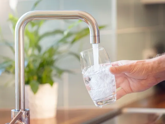 A stock image of a glass being filled with tap water