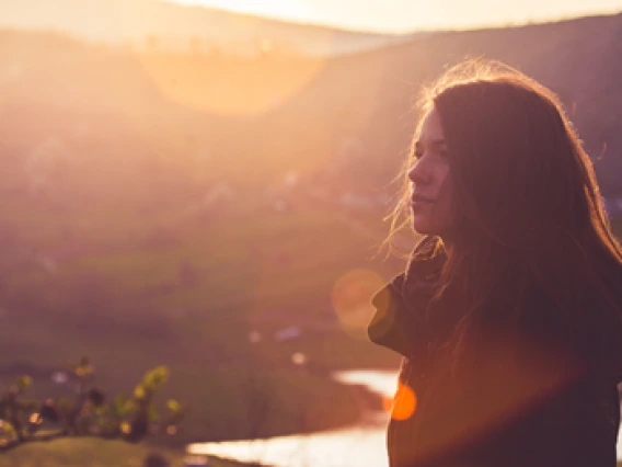 Image of a woman next to a sunset
