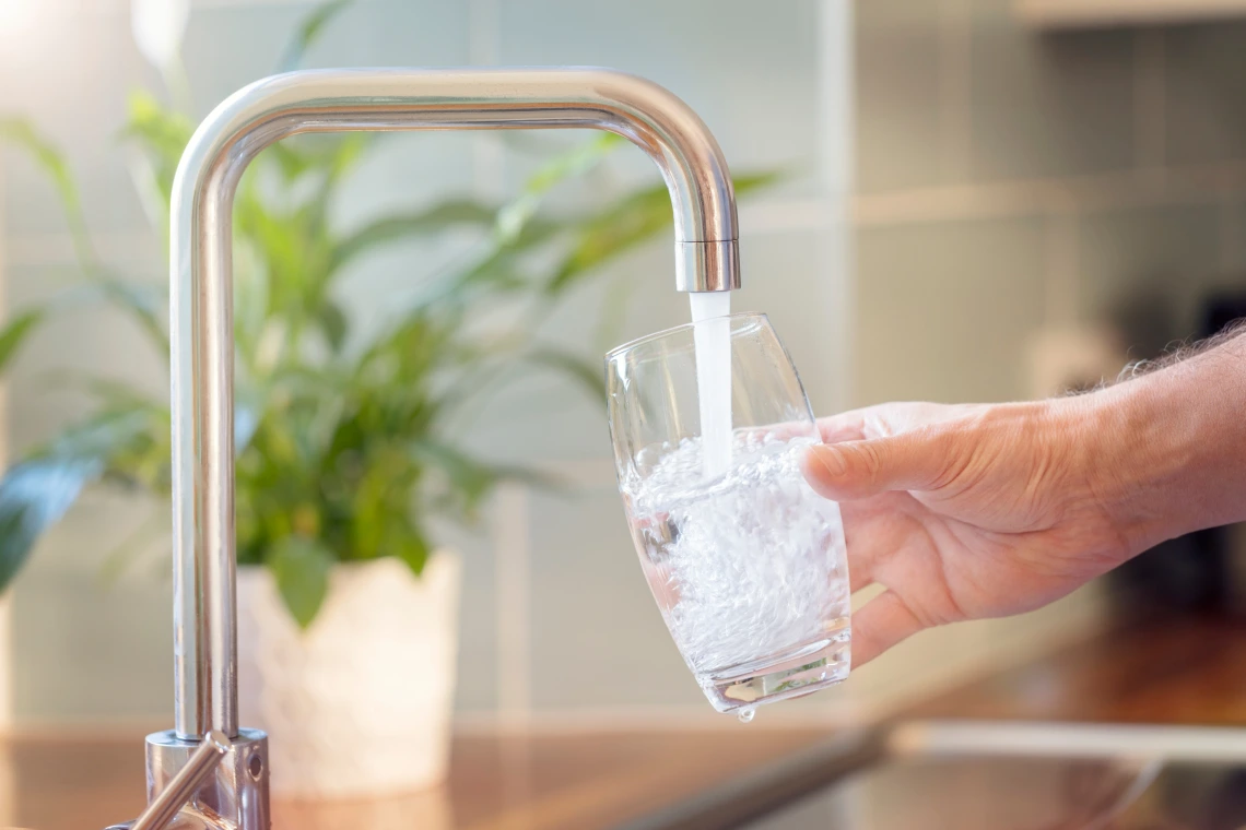 A stock image of a glass being filled with tap water