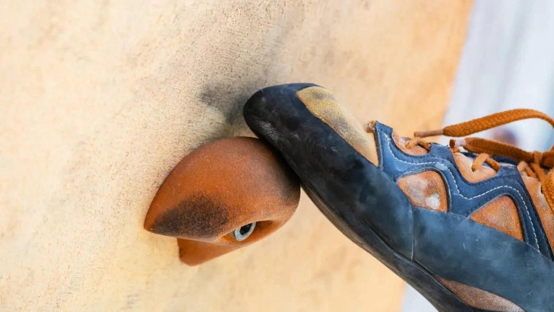 A close-up of a person’s climbing shoes