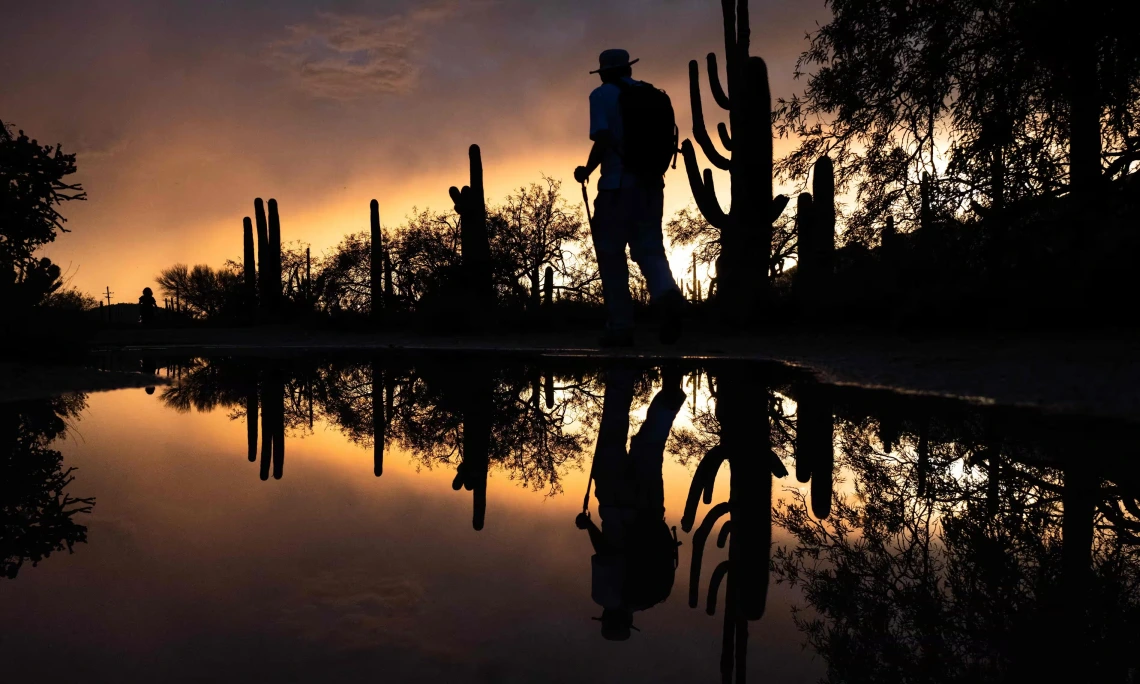 A picture of a person walking next to a body of water 