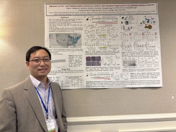 a man stands in front of an academic poster