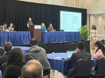 a panel presentation with a speaker in the center