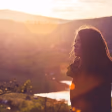 Image of a woman next to a sunset